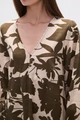 Vestido midi holgado con estampado floral en tonos verde militar y beige, cuello en V, mangas largas y falda con volados.