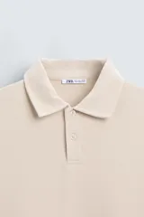 Polo manga larga negro de algodón con elasticidad y estructura. Cuello solapa con cierre frontal de botonadura y acabados con rib.