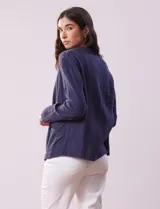 Chaqueta azul de algodón con bolsillos simulados y terminación desflecada.