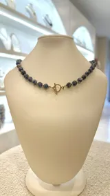 Collar corto de cuentas de piedra natural lapislázuli azul con detalles dorados y cierre marinero.