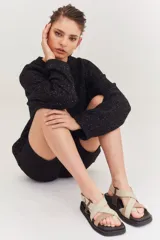 Sandalias con plataforma negra y tiras cruzadas en tonos beige y marrón.