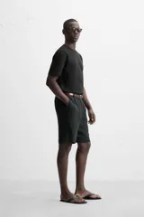 Camiseta negra de algodón de corte regular, con cuello redondo con ribete doble y mangas cortas.