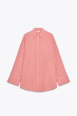 Camisa oversize color salmón con rayas verticales finas en color negro. Cuello solapa, manga larga con puños y cierre frontal con botones.