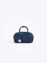 Baulito Lucky de cuero descarne vacuno color azul, con gofrado JCH en la tapa delantera. Incluye correa larga desmontable y regulable. Lleva un charm Lady Bag en el tag.