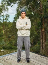 Hoodie color crema con capucha y manga larga, de corte holgado y estampado frontal con un personaje de caricatura y la frase "Totally Legit".