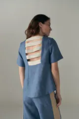 Top azul de manga corta con escote redondo y detalle de tiras en el frente.