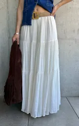 Pollera larga de color blanco con vuelo y cinto playero de soga con hebilla de madera.