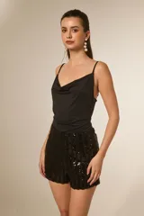 Body de bretel fino, color negro, con cuello buche drapeado y ajuste al cuerpo.