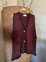 Chaleco tejido color marrón con detalles de lurex, escote en V, bordado con botones, terminaciones en crochet y bordados hechos a mano con lana merino.