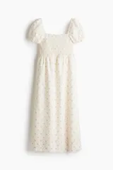 Vestido largo de algodón color crudo con estampado de pequeñas flores rosas, escote cuadrado, mangas cortas abullonadas con elástico y cuerpo fruncido.