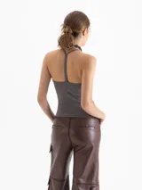 Top de punto color marrón, ajustado al cuerpo, con escote en V pronunciado y tirantes finos que se unen en la espalda.