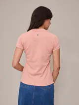 Remera polo de piqué color salmón con cuello clásico y tapeta de botones.