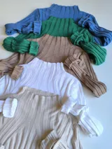 Polera de punto acanalado con cuello alto y mangas largas.