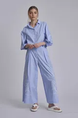 Pantalón palazzo azul marino con bordado de flores blancas en la parte inferior de ambas piernas.