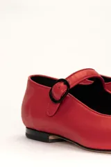 Zapato estilo Mary Jane color marrón, de cuero, con punta redondeada y tira sobre el empeine con hebilla.