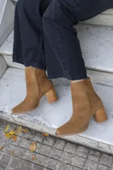 Bota corta color marrón de gamuza, con punta cuadrada, cierre lateral y taco de madera.