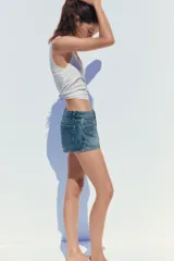 Short de jean de tiro medio, con cinco bolsillos y cierre frontal con cremallera y botón metálico.