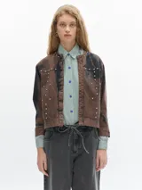 Campera marrón de denim con efecto lavado, cuello redondo y tachas plateadas.