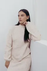 Vestido de punto de color verde con cuello semi alto y mangas globo, de corte recto y relajado.