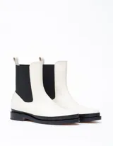 Bota Chelsea color crema de cuero vacuno, con elástico lateral negro, suela de cuero y taco de 2,5 cm. Hecha a mano en Argentina.