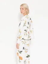 Buzo blanco estampado con flores y la palabra "MERCI" en el frente.