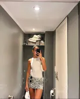 Minifalda plateada con lentejuelas circulares, tiro bajo y cintura elástica.