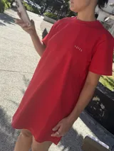 Vestido túnica rojo con cuello redondo y mangas cortas. Estampado frontal con la palabra 'SAVIA' en letras doradas.