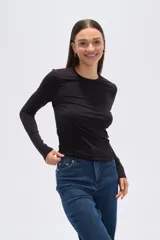 Remera negra de manga larga, corte ajustado y cuello redondo.