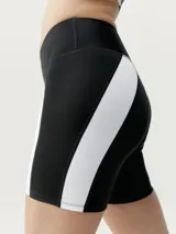 Short biker negro con bandas laterales blancas. Tejido Shapplex_B efecto moldeador. Incluye un bolsillo en la parte trasera de la cinturilla.