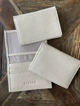 Tarjetero de cuero vacuno color celeste con ranuras para tarjetas y bolsillo exterior.