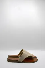 Sandalias bajas color beige con capellada cruzada de neopreno y plantilla de cuero.