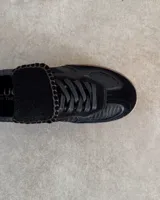 Sneakers bajas de cuero vacuno color bordó con suela marrón.