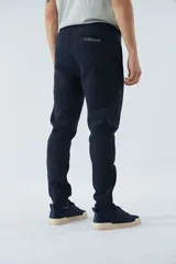 Pantalón de jogging negro de felpa con logo estampado y en goma, bolsillos con cierre, cierres en los tobillos, cintura ajustable y puños.