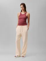 Pantalón de corte recto color beige, de gasa doble con textura arrugada, cintura elástica con cordón ajustable, bolsillos laterales y trasero.