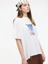 Camiseta blanca de algodón con cuello redondo y mangas cortas. Estampa frontal con la frase "Ride the Wave" y una imagen de una persona surfeando.