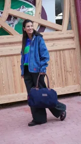 Bolso de mano azul marino con doble asa corta marrón y etiqueta de cuero con logo grabado.
