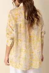 Camisa estampada con flores amarillas y lilas, de corte recto y mangas largas.