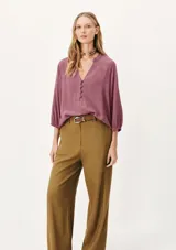Blusa color verde claro, de mangas 3/4 con elástico en los puños, escote en V con botones y corte holgado.