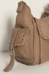 Bolso mini de cuero desgastado color beige claro, con cierre magnético plegable, monedero forrado y bolsillos interiores. Incluye correa de hombro extrapole.