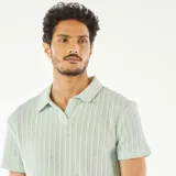 Remera de punto gofrado color celeste con cuello polo y mangas cortas.