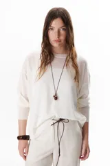 Sweater beige de tejido fino y mangas largas.