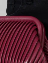 Cartera clutch color bordó, con diseño plisado vertical y asa de cadena metálica removible. Incluye bolsillo interior.