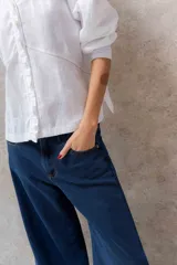 Blusa de manga larga color crudo con botones frontales y cuello redondo.