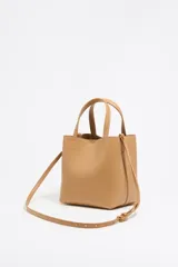 Bolso tote pequeño de piel reconstituida color gris claro, con estructura rígida, doble asa corta, correa extraíble, cierre con botón de presión, logo metálico BIMBA Y LOLA, acabados metálicos, bolsillo interior con cierre de cremallera e interior con logo grabado.