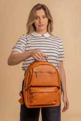 Mochila color tostado en símil cuero, con un compartimento principal amplio, bolsillo frontal con cierre y correas ajustables.