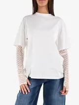 Camiseta blanca de algodón con mangas cortas y mangas largas de encaje color crema debajo.