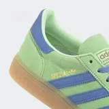 Championes Adidas modelo Handball Spezial con empeine de ante premium en color verde menta y detalles de cuero en color violeta. Presenta las icónicas tres tiras laterales, suela de goma color caramelo y cierre mediante cordones.