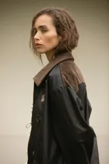 Campera impermeable color negro con detalles en pana chocolate y herrajes de metal dorado.