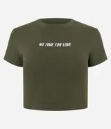 Blusa baby look verde militar de algodón con elastano, cuello redondo, mangas cortas y estampado frontal con la frase "No Time For Love" en color blanco.