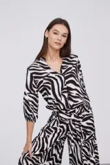 Blusa color beige con estampado abstracto en tonos marrones, de viscosa, corte al cuerpo y cuello en V.